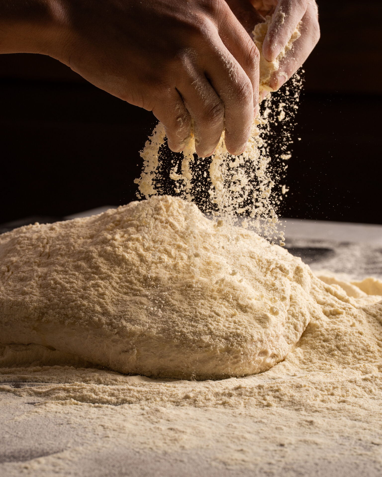 Mani che lavorano l'impasto al farro